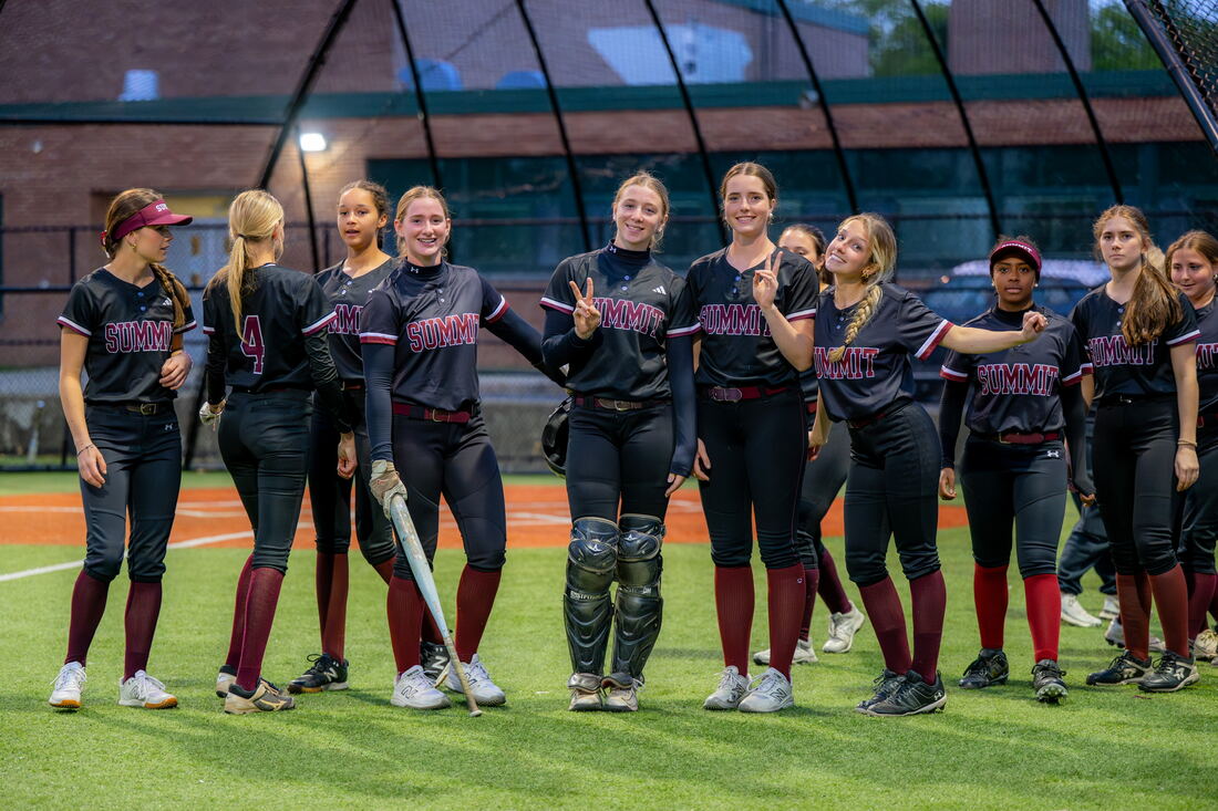 Players smiling and posing in the batting cage