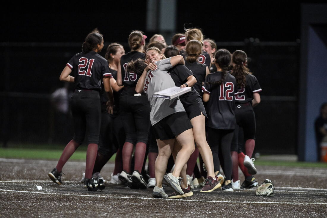 Coach hugging a player in celebration on the field